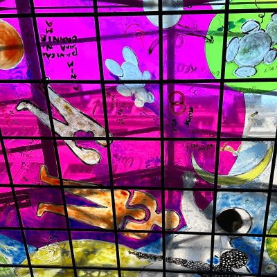 The vibrant glass ceiling adds a poetic, almost dreamlike layer—an artistic signature that defines the space.