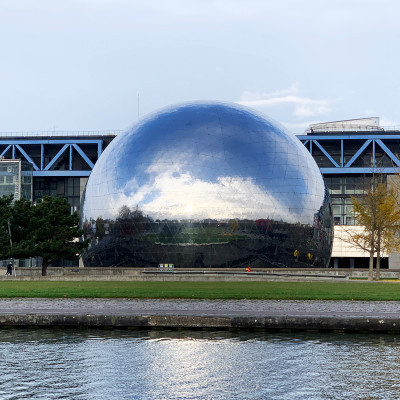 The striking mirrored surface of La Géode creates ever-changing reflections throughout the day, making it one of Paris's most photographed examples of contemporary architecture and a landmark within Parc de la Villette.