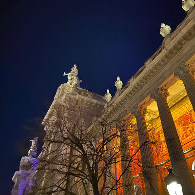Grand Palais at night — glowing interiors and dramatic columns against the Paris sky.