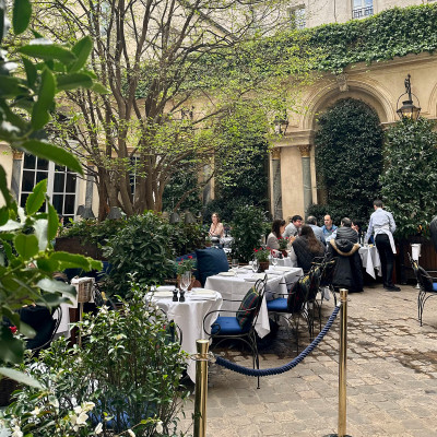 Hidden behind the façade, a courtyard where Paris slows down into long lunches and quiet conversations.