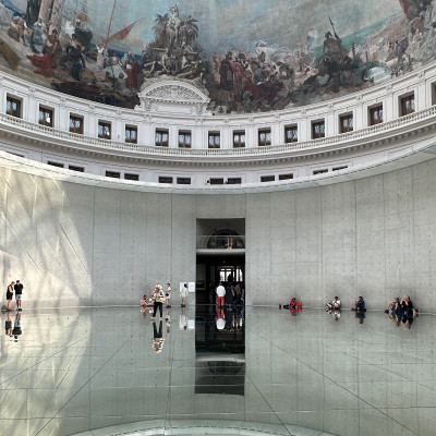 Natural light filters through the glass dome, creating an ever-changing atmosphere where architecture, art, and visitors become part of the installation itself.
