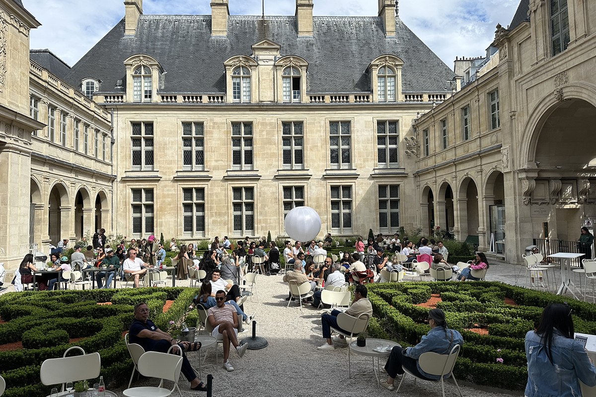 Visitors gather beneath the arcades of the museum's historic courtyard, where centuries of Parisian history meet a relaxed contemporary atmosphere at Musée Carnavalet.