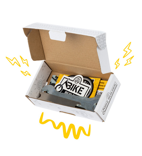 Strider Tool Kit shown open with six wrenches, stickers, and cards inside. Yellow doodles surround the box for emphasis.
