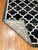 Corner of the rug is flipped up showing detail and texture on the bottom.