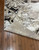 Corner of the rug is flipped up showing texture on the bottom.