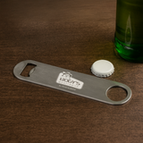 <p>The Bartender’s Bottle Opener is the go-to tool for professionals. Made from durable stainless steel, it’s designed for both reliability and comfort. Sleek and easy to use, this bottle opener offers a smooth and efficient experience every time, making it a must-have for bars, events, or home setups.</p>
<p>Epoxy – Overseas Sourcing<br />
Please note a standard digital transfer CMYK cannot be exactly PMS matched. To convert artwork colours from CMYK to PMS is additional charges per colour.</p>
<p>Note : Epoxy Dome service is 15 days</p>
<p>Keywords: metal, alcohol</p>
