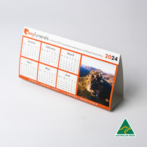 <p>Make your mark with these custom printed desk calendars. A clever and memorable giveaway for your next marketing campaign. These foldable calendars aren’t just practical, they’re a great way to get your logo seen every day. With the option for repositionable tape on the base, they’ll stay put on computer monitors or shop counters, ensuring your message is always front and centre. Customise them as a year calendar, with months, memorable moments, or highlight special days, whatever suits your message best.</p>
<p>&nbsp;</p>
<p>(Also known as variable-information printing (VIP) or VI) is a form of digital printing, including on-demand printing, in which elements such as text, graphics and images may be changed from one printed piece to the next, without stopping or slowing down the printing process and using information from a database or external file.<br />
For example, a set of labels, each with the same basic layout, can be printed with a different name on each label. Variable data printing is mainly used for direct marketing, customer relationship management, advertising, invoicing and applying addressing on selfmailers, brochures or postcard campaigns.<br />
“Not intended for washing/submerging into water, to clean coasters please wipe down with a damp cloth only”.</p>
