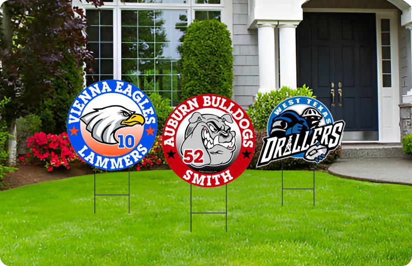 Three team yard signs on a grass-covered lawn