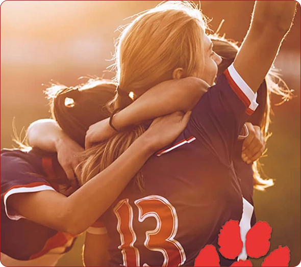 Young teammates in their uniforms, hugging after scoring 