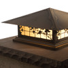 A classic, traditional sloped-roof column mounted pier light fixture with crown molding accent, an aged bronze finish, floral artwork and golden glass. 