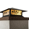 A classic, traditional sloped-roof column mounted pier light fixture with crown molding accent, a bronze finish, warm colored glass and floral artwork. 