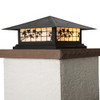A classic, traditional sloped-roof column mounted pier light fixture with crown molding accent, a black finish and white glass. 