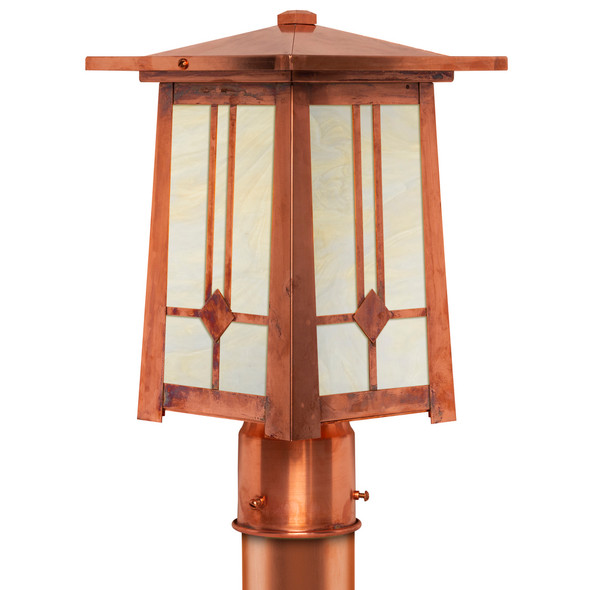 A linear Arts & Crafts post mounted light fixture with a raw copper finish, off white glass and a linear lozenge pattern