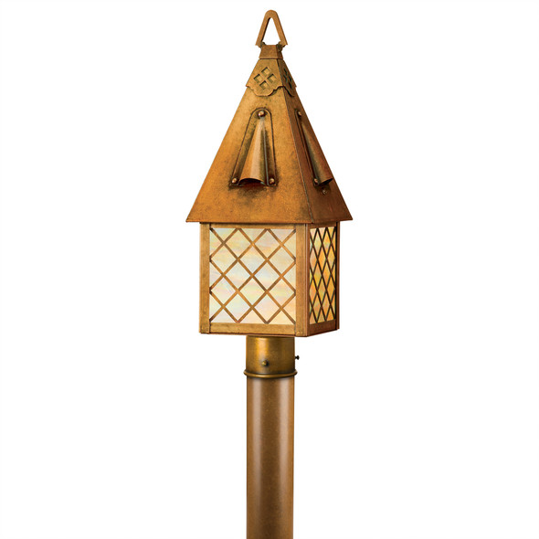 A Tudor Revival lantern post mount light fixture for a cottage, storybook, or fairy tale themed home made with warmly finished brass, a cross hatch pattern and iridescent glass.