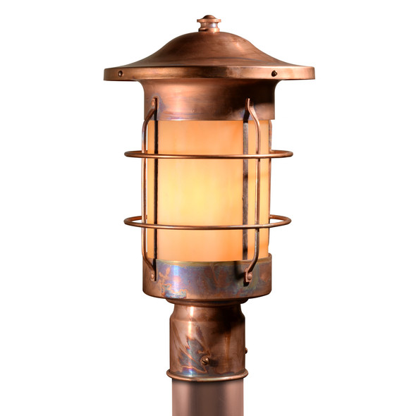 A nautical, streamlined post lamp or lantern with a natural copper finish that ages and patinas over time with warm, glowing glass.