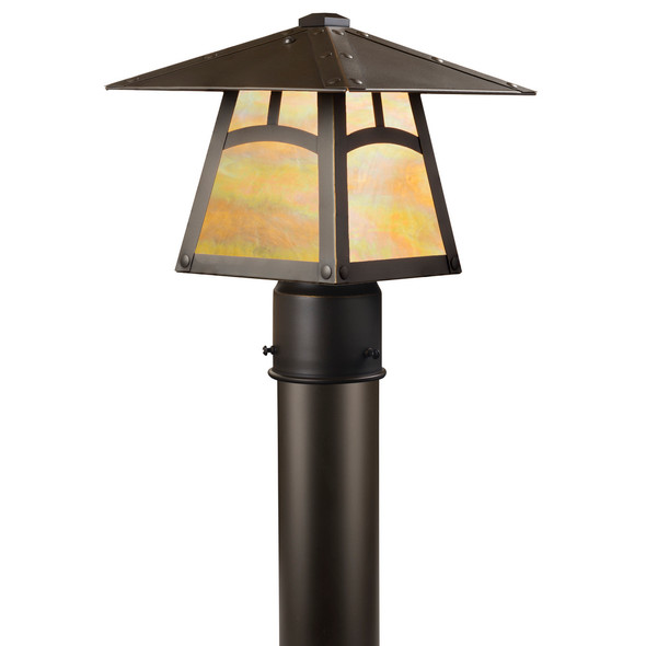 A classic Arts & Crafts style post mounted light fixture with a heavy taper, a bronze finish and iridescent glass.