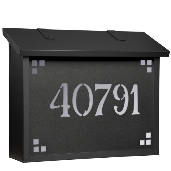 A large brass mailbox with a black finish, glass corner accents and address numbers on the front backed by glass. 