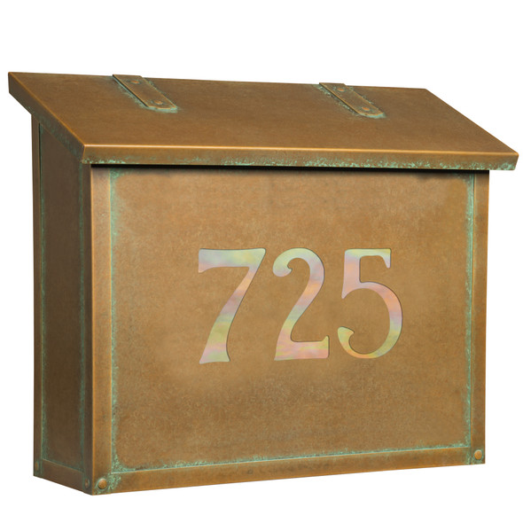 A classic, solid brass, large mailbox with an aged patina finish and glass-backed house address numbers. 