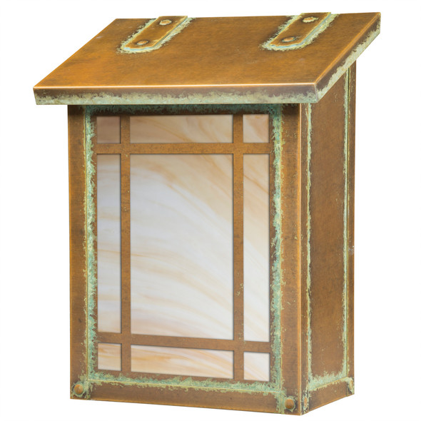 A vertical brass mailbox with an aged patina finish, warm toned glass and a rectilinear border.