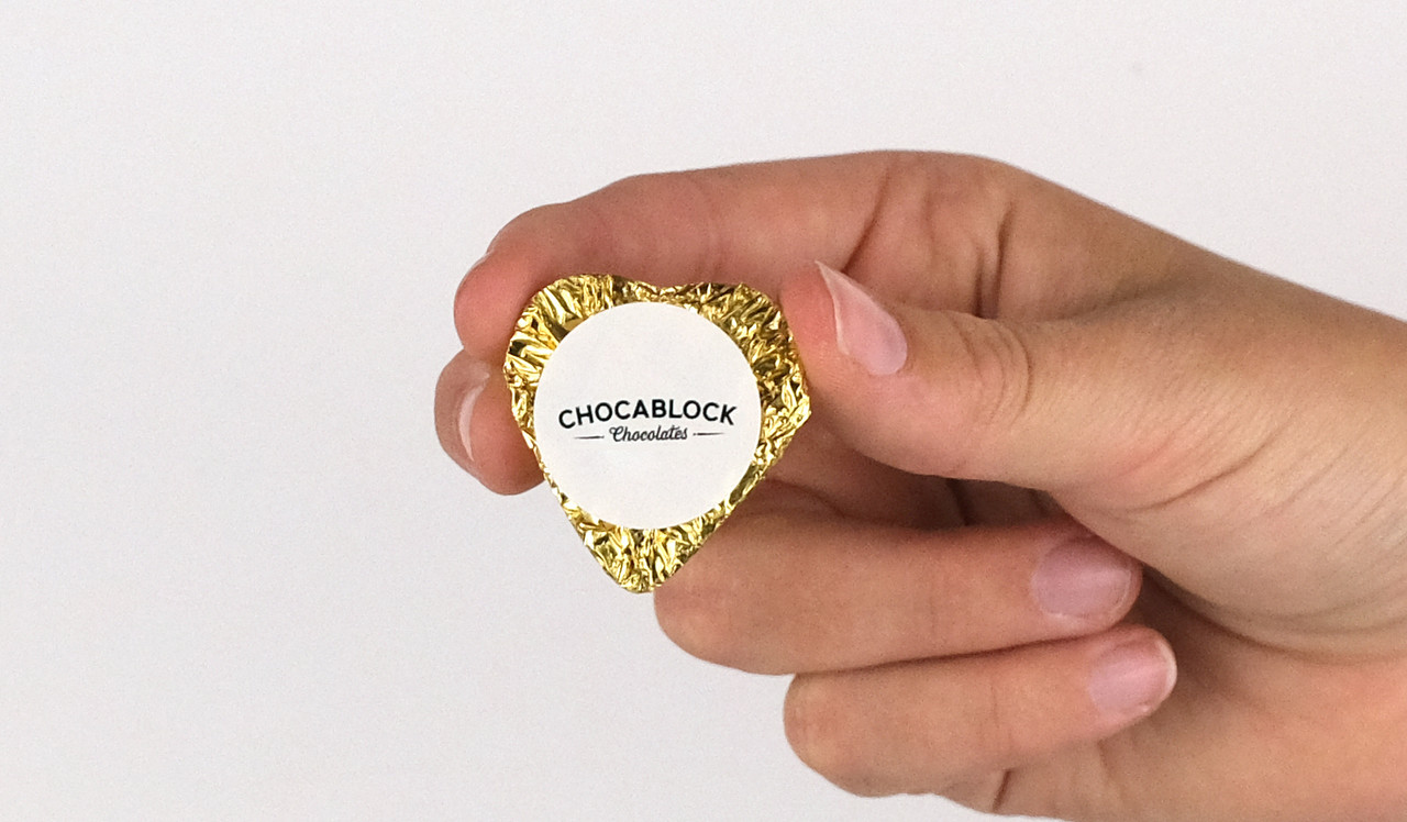 Model holding heart chocolates for size comparison