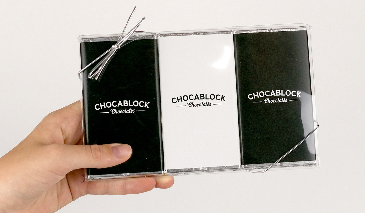 Model holding trio of chocolate bars for sizing comparison
