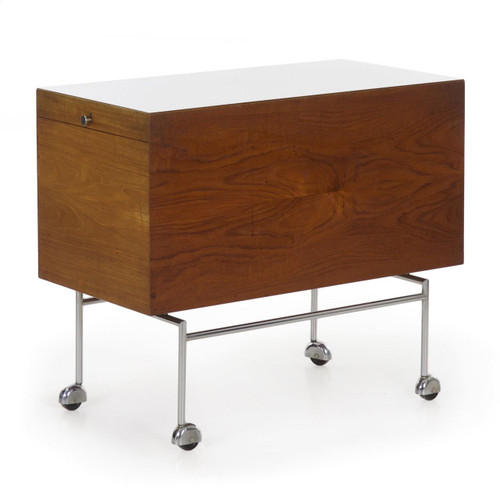 An unusual and rather excellent serving cart, it is crafted with figured teak veneers with white laminate serving surfaces and rides over polished metal legs.  