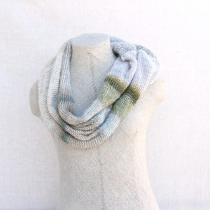 Snow kid mohair and silk one of a kind loop scarf on dress form with white background. Knit by Inese in white, silver sparkle, green, grey