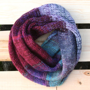 Midsummer Dawn color way snood cowl flat on wood pallet background, knit by Inese Iris Liepina for Wrapture by Inese.