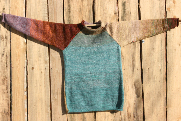 Fragments unisex reversible raglan pullover sweater on wood shed