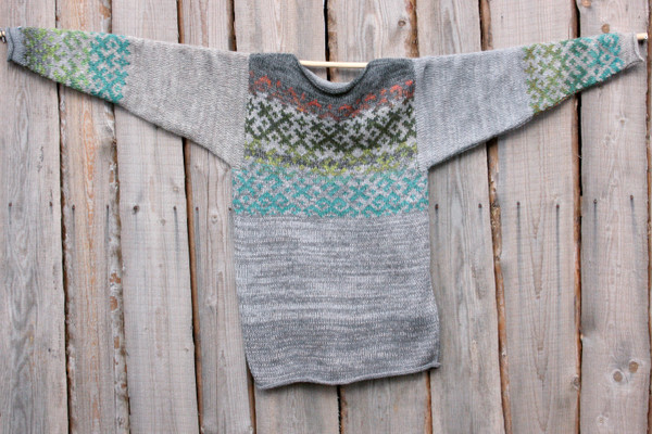 Grey Forest Latvian symbols sweater flat on side of woodshed size L