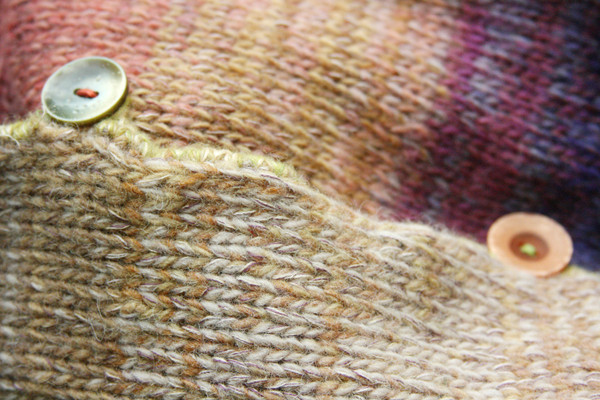 Closeup of Bitene M felted wool coat unmatched button detail with crochet edge and button loops. Knit by Wrapture by Inese