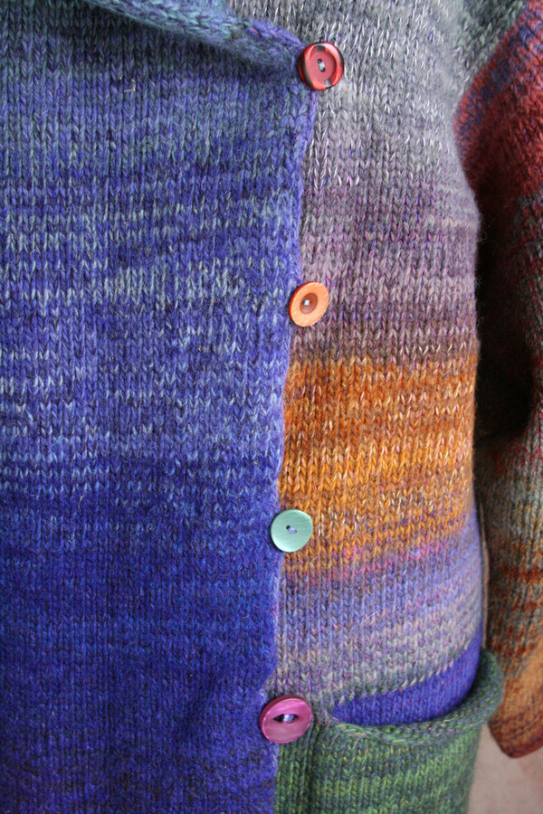 Closeup of Plum S felted wool coat unmatched button detail with crochet edge and button loops. Knit by Wrapture by Inese