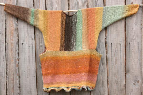 Ancient Woods inspired scalloped hem sweater reversible dress hung on wood pole on side of woodshed, knit side out, knit by Wrapture by Inese