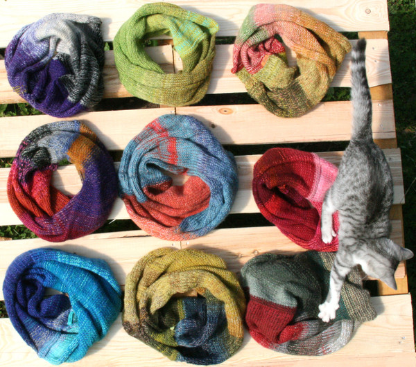 9 cowls on wood pallet with kitten, knit by Wrapture by Inese