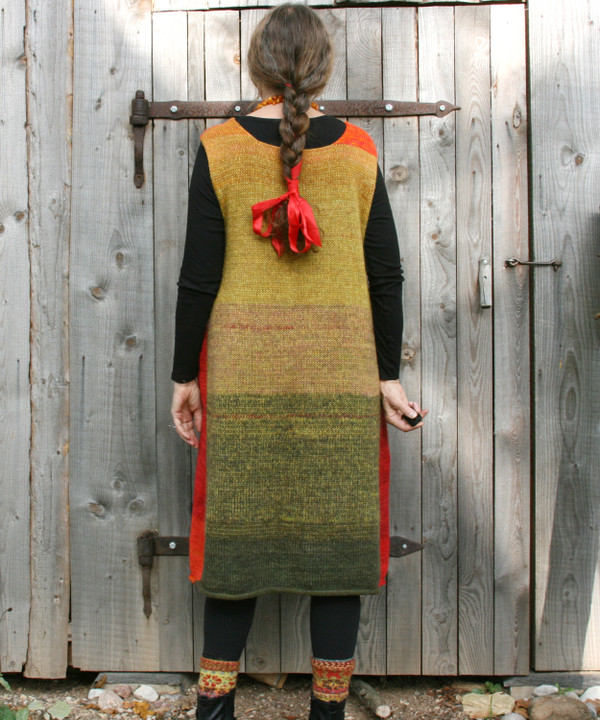 Back view of trapeze dress and boot toppers worn by Inese Iris Liepina in front of a woodshed.