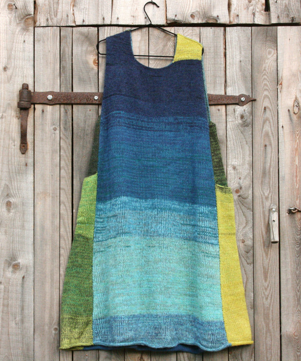 Mirror Lake trapeze dress on coathanger hung on woodshed door knit by Inese iris Liepina of Wrapture by Inese