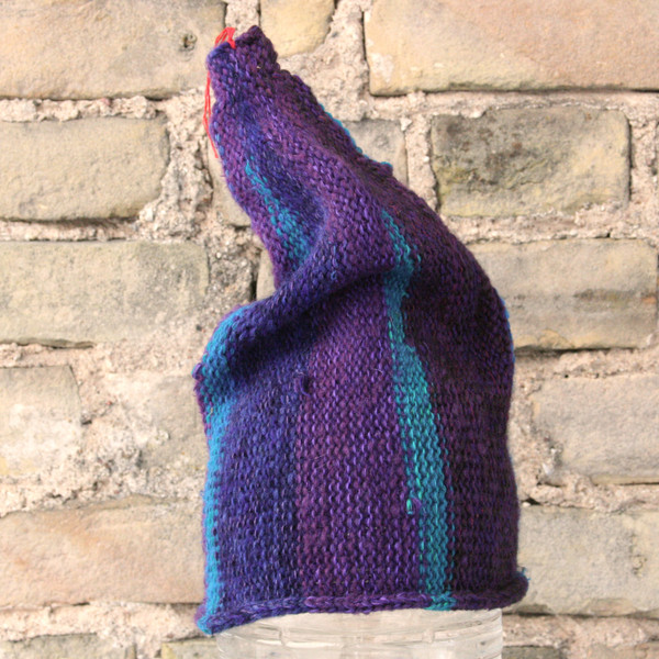 Twilight S/M pixie gnome hat knit by Wrapture by Inese in front of brick wall