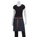 Indigo denim half waist apron with tan faux-leather tie straps and front patch pockets, worn by mannequin