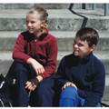 Children wearing polar fleece jackets in maroon with black contrast and navy, showing relaxed fit and full zip front