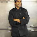 Black double-breasted chef jacket with press stud closure and long sleeves worn by male chef in kitchen