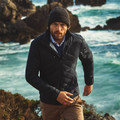 Black quilted puffer jacket with high collar and zip front worn over light blue shirt
