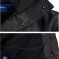 Charcoal longline jacket detail showing snap-button storm collar, concealed zip placket and zippered side pocket
