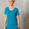 Woman wearing teal short sleeve top with front pleat detail and scoop neckline