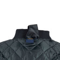 Close-up of slate blue quilted nylon jacket showing ribbed collar, concealed zip placket and diamond-stitch pattern