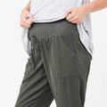 Olive green maternity pants with elasticated smocked waistband, drawstring ties, and side pockets