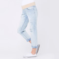 Light blue wash distressed boyfriend maternity jeans with nude elasticated waistband and rolled cuffs, worn by model