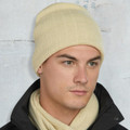 Cream cable knit beanie with fleece band worn with matching scarf over black jacket