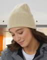 Cream cable knit beanie with ribbed texture and cuffed design shown on model