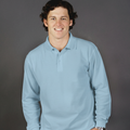 Smiling male model wearing a sky blue long sleeve polo shirt from Marsden, ideal for casual and uniform wear.