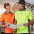 Man and woman in hi-vis yellow and orange contrast-panel Cooldry polo shirts on construction site